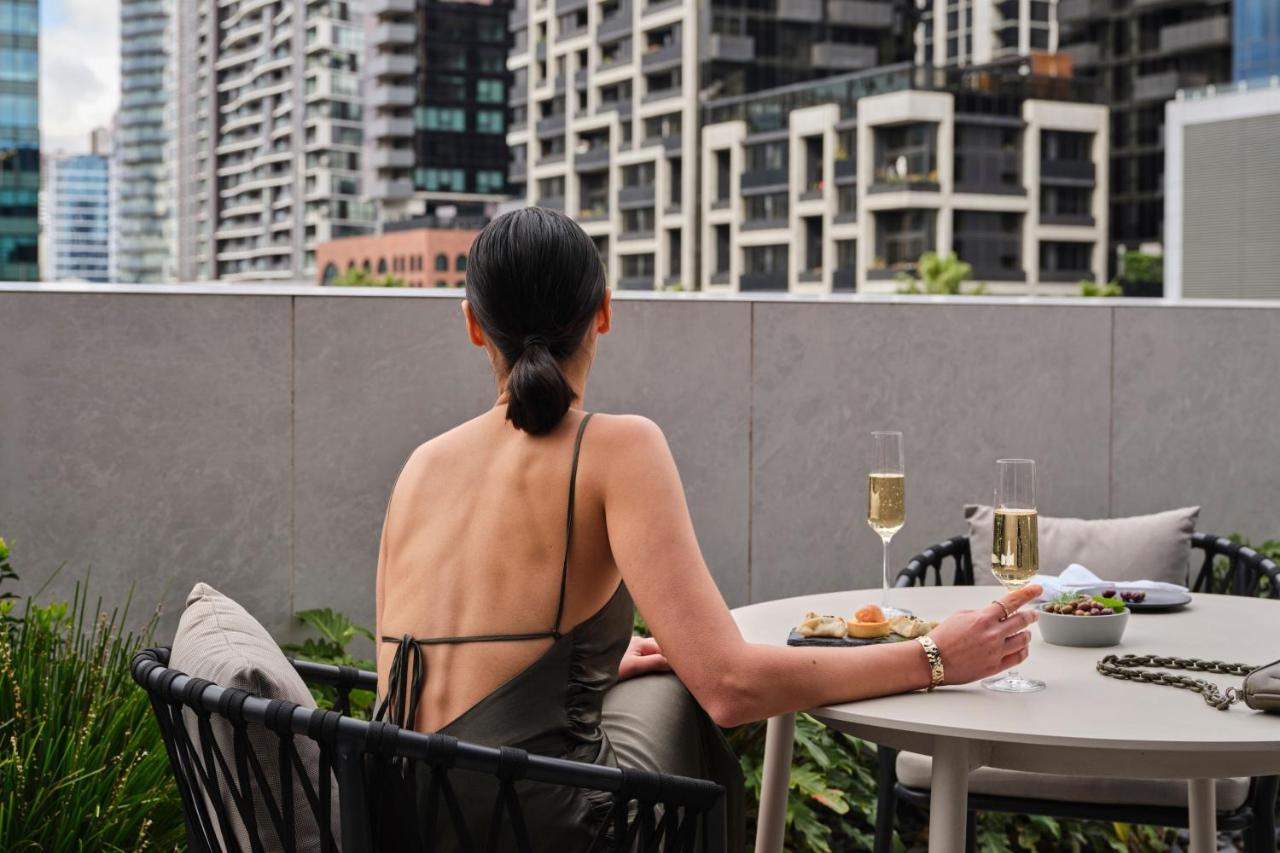 Melbourne Marriott Hotel Docklands Buitenkant foto A woman sitting on a balcony